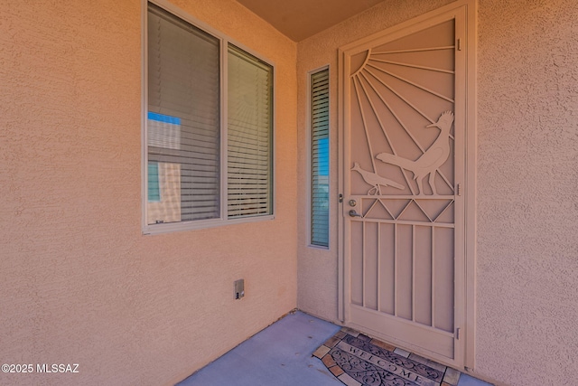 view of exterior entry with stucco siding