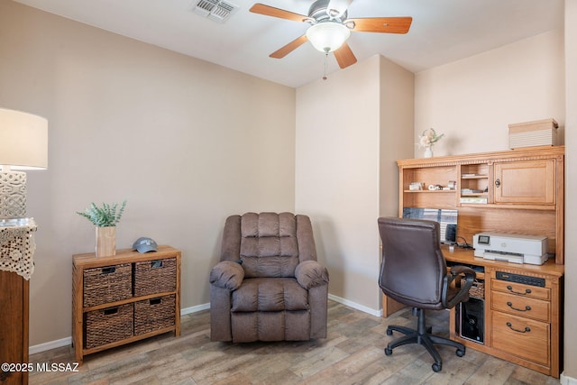office with light wood-style flooring, visible vents, a ceiling fan, and baseboards