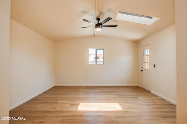 unfurnished room featuring ceiling fan, a healthy amount of sunlight, lofted ceiling with skylight, and light wood-style flooring