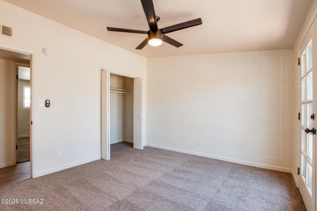 unfurnished bedroom featuring baseboards, a closet, multiple windows, and carpet
