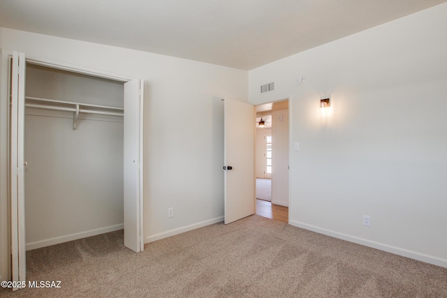 unfurnished bedroom featuring a closet, visible vents, carpet flooring, and baseboards