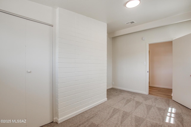 unfurnished bedroom featuring visible vents, baseboards, carpet flooring, and a closet