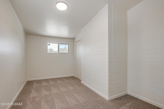 empty room featuring carpet and baseboards