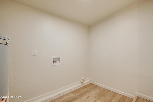 washroom featuring baseboards, light wood-style floors, hookup for a washing machine, water heater, and laundry area