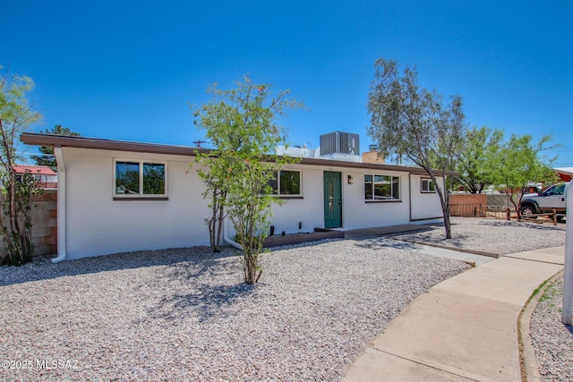 ranch-style home with central AC, a chimney, and fence