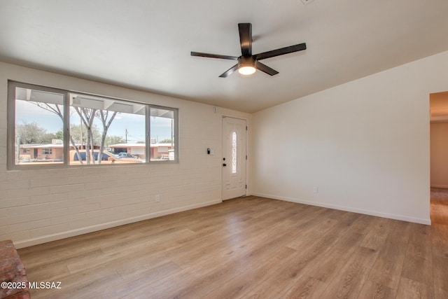 interior space featuring light wood-style flooring, baseboards, and ceiling fan