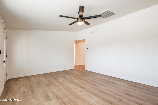 empty room featuring light wood finished floors, visible vents, a ceiling fan, and baseboards
