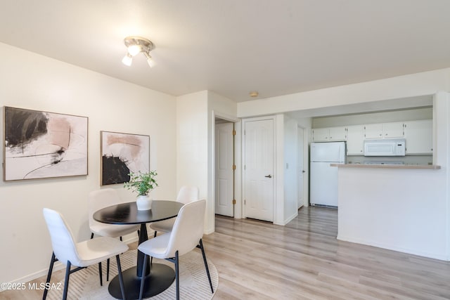 dining room featuring light wood-style floors and baseboards