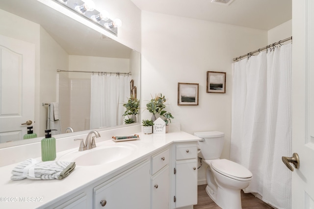full bathroom with vanity, toilet, wood finished floors, a shower with curtain, and visible vents