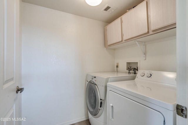 laundry room with baseboards, visible vents, cabinet space, and washing machine and clothes dryer