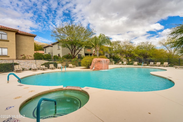 view of pool featuring a patio, a pool with connected hot tub, and fence