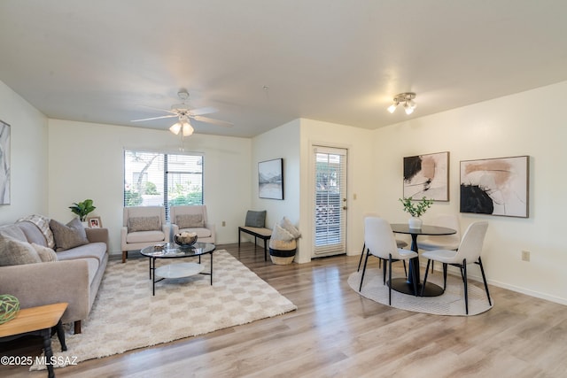 living room with light wood-type flooring, baseboards, plenty of natural light, and ceiling fan