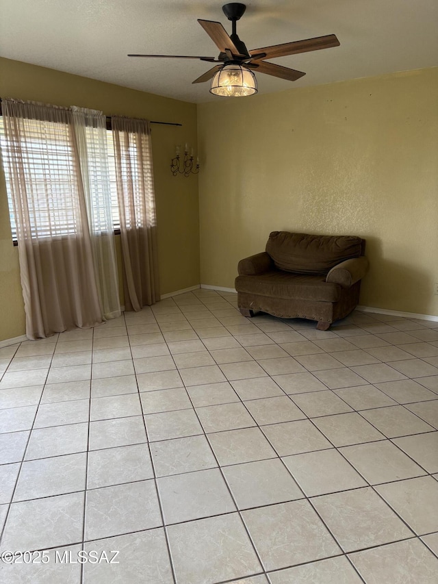 unfurnished room with ceiling fan, baseboards, and light tile patterned floors