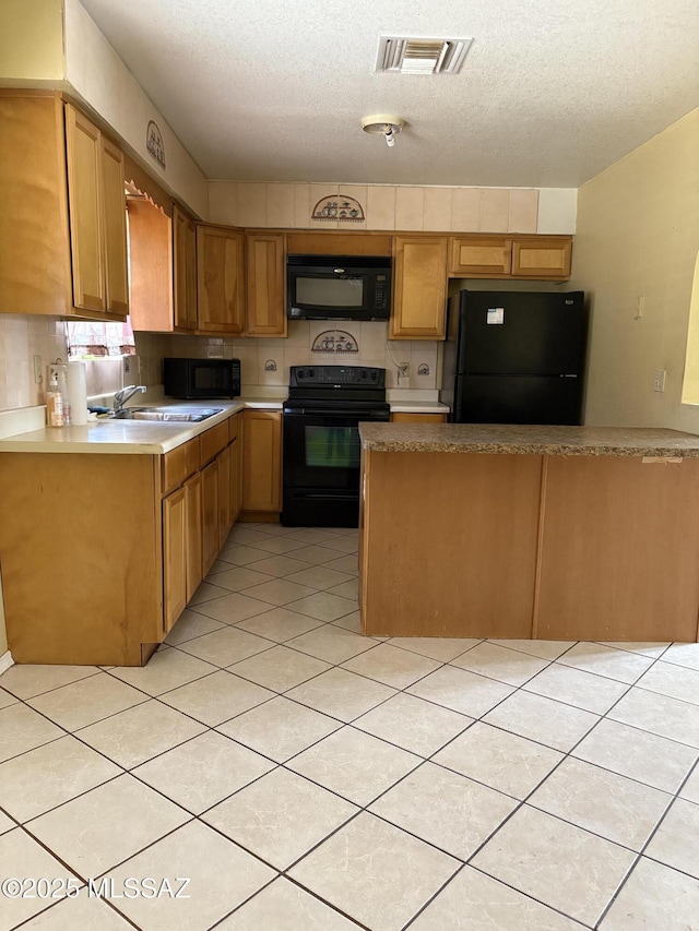 kitchen with a sink, a textured ceiling, visible vents, black appliances, and light tile patterned floors