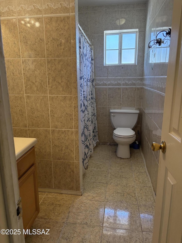 full bathroom featuring curtained shower, tile walls, toilet, and vanity