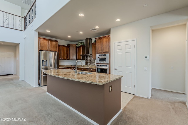 kitchen featuring light colored carpet, light stone countertops, a sink, stainless steel appliances, and wall chimney exhaust hood