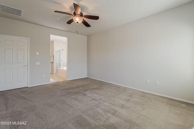 unfurnished bedroom featuring baseboards, visible vents, carpet, and ensuite bath