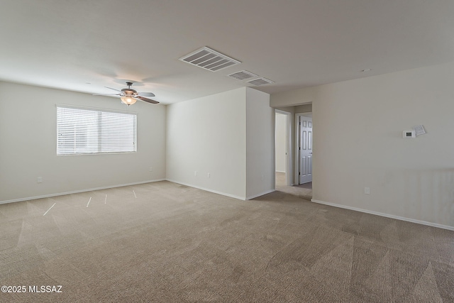 spare room with baseboards, ceiling fan, light carpet, and visible vents