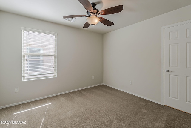 carpeted empty room featuring baseboards, ceiling fan, and visible vents