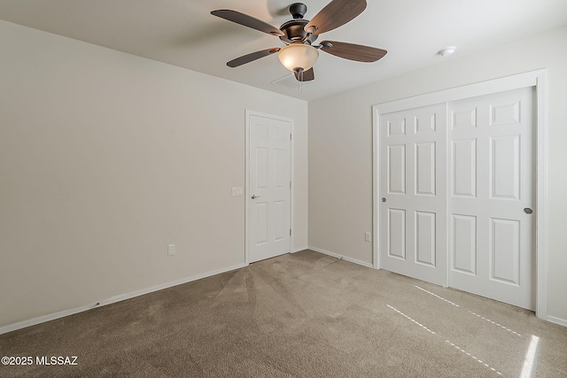 unfurnished bedroom featuring carpet floors, baseboards, a closet, and ceiling fan