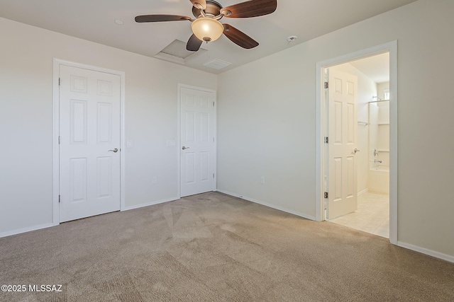 unfurnished bedroom featuring baseboards, visible vents, light carpet, and ensuite bath