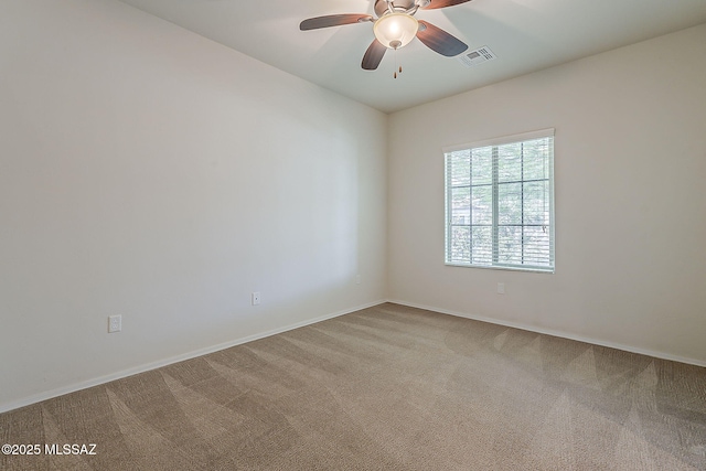 carpeted empty room featuring ceiling fan, visible vents, and baseboards