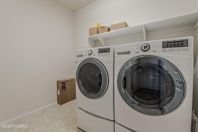 laundry room featuring laundry area, baseboards, and washing machine and dryer