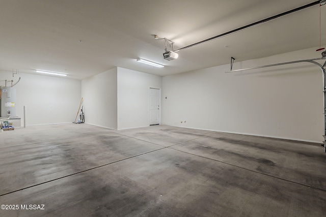 garage with baseboards, a garage door opener, and electric water heater