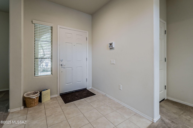 foyer with light tile patterned floors and baseboards