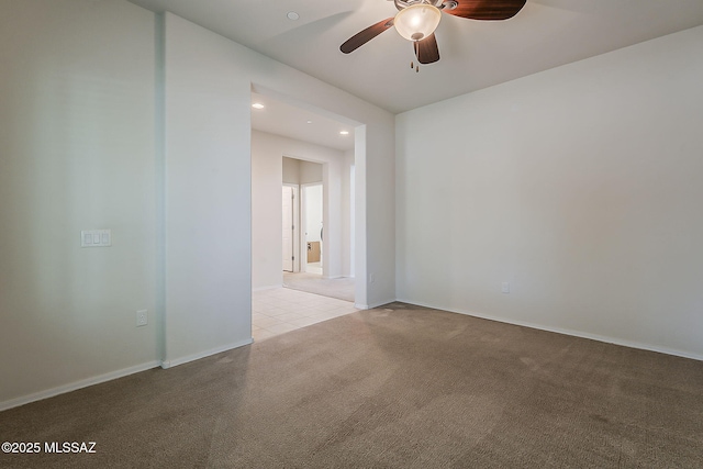 carpeted spare room featuring recessed lighting, a ceiling fan, and baseboards