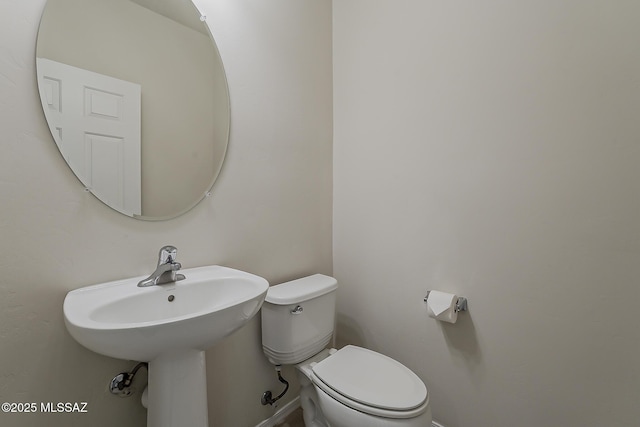 bathroom featuring baseboards and toilet