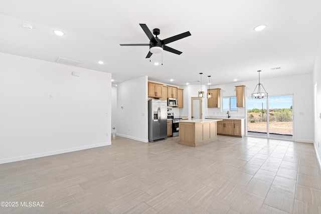kitchen featuring stainless steel appliances, a center island, open floor plan, recessed lighting, and light countertops