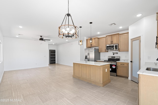kitchen featuring recessed lighting, a kitchen island, stainless steel appliances, and ceiling fan with notable chandelier