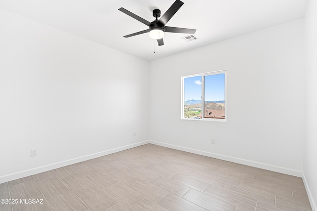 unfurnished room featuring baseboards, a ceiling fan, and visible vents