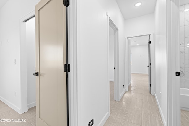 hallway featuring baseboards and recessed lighting