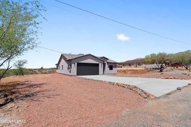 ranch-style home with stucco siding, driveway, and a garage