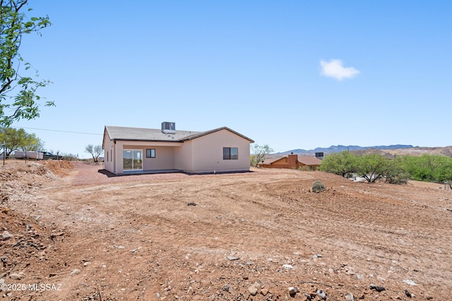 back of house featuring stucco siding and a mountain view