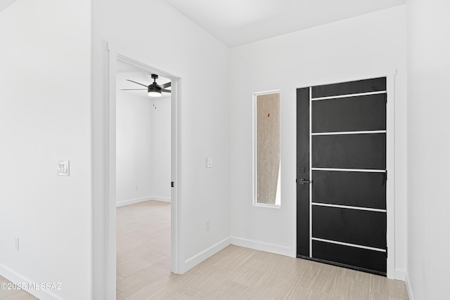 interior space featuring baseboards and ceiling fan