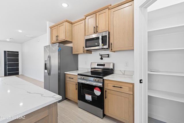 kitchen with light stone counters, light brown cabinetry, stainless steel appliances, and recessed lighting
