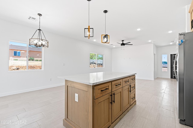 kitchen featuring ceiling fan with notable chandelier, freestanding refrigerator, baseboards, visible vents, and recessed lighting