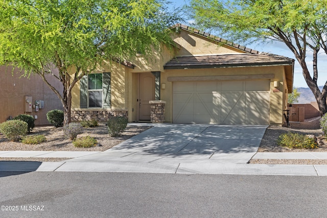 view of front of property with stucco siding, driveway, stone siding, and a garage