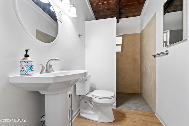 bathroom featuring beam ceiling, wood finished floors, toilet, baseboards, and wooden ceiling