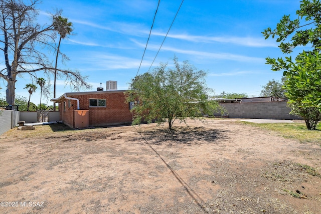view of yard with a fenced backyard and a gate