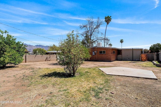 view of yard with a patio, a mountain view, fence, and central air condition unit