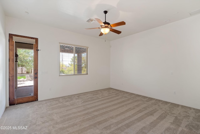 spare room featuring ceiling fan, carpet, and visible vents