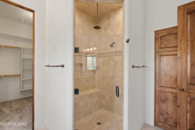 full bath featuring a spacious closet, a shower stall, and visible vents