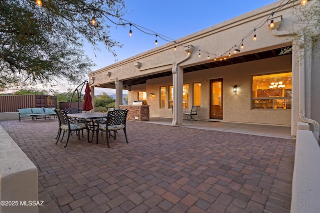 view of patio featuring outdoor lounge area, fence, exterior kitchen, and outdoor dining space