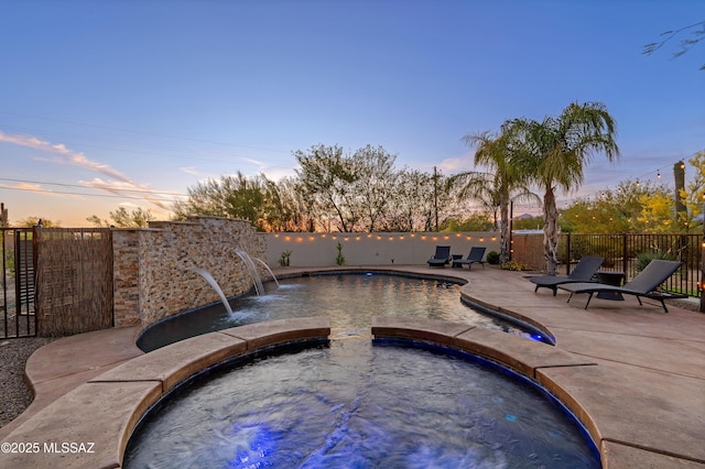 view of swimming pool featuring a patio, a pool with connected hot tub, and a fenced backyard