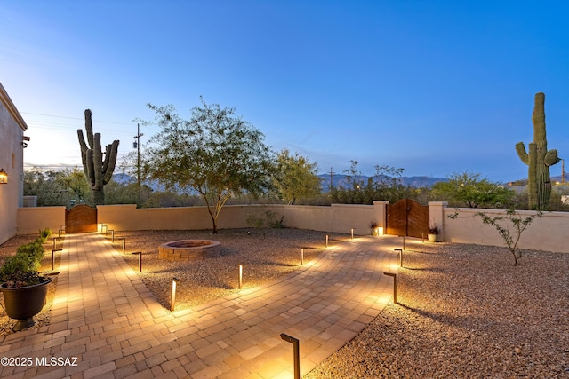 view of patio / terrace with a gate, a fire pit, and fence private yard