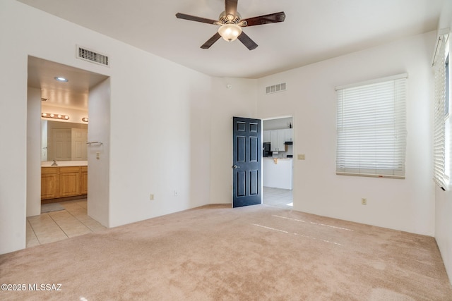 1320 S Via Estrella Roja, Tucson, AZ 85713 - empty room with a ceiling fan, light carpet, and light tile patterned floors